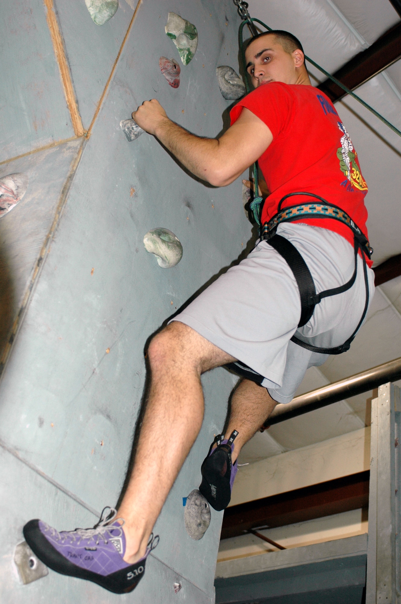 Brody Johnson climbs “The Tower” at the Outdoor Recreation Indoor Climbing Wall. The Tower features a large overhang with few holds on the wall to provide a challenging climb. The climbing wall is open every day and is free for active duty. However, climbers must bring their own belayers. Belayers are the people on the other end of the rope who control the falling climber so they do not fall very far. (U.S. Air Force photo by Jennifer Brugman/60th Air Mobility Wing Public Affairs)
