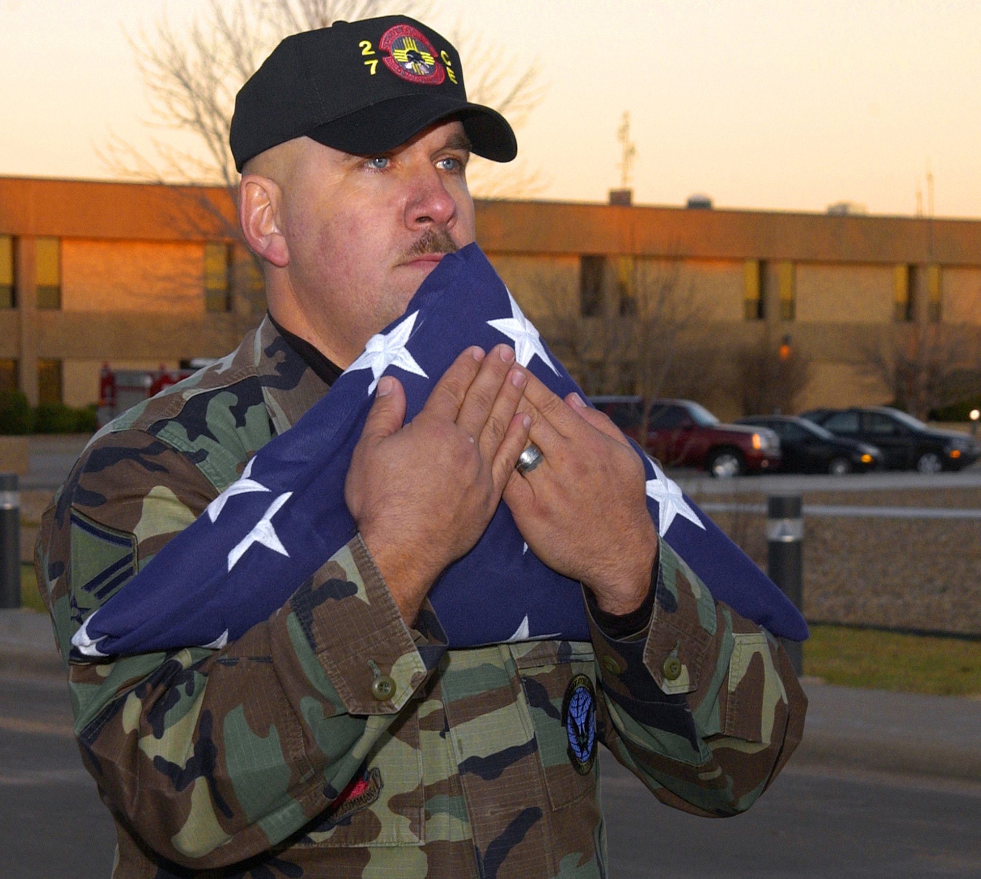 Honor guard member Master Sgt. Eric Butt cradles the flag flown in honor of Capt. Kermit Evans, after a special retreat ceremony Dec. 6 at Cannon Air Force Base, N.M. Captain Evans was killed in an emergency helicopter landing Dec. 3 near the shore of Lake Qadisiyah in western Al Anbar Province, Iraq. He was one of 16 people aboard the Marine CH-46 helicopter and one of four servicemembers killed as a result of the landing. Captain Evans was the commander of the 27th Civil Engineer Squadron's Explosives Ordnance Disposal Flight. The flag will be placed in a shadow box for his wife, Perneatha, and 13-month-old son, Kermit Jr. (U.S. Air Force photo/Senior Airman Heather Redman)