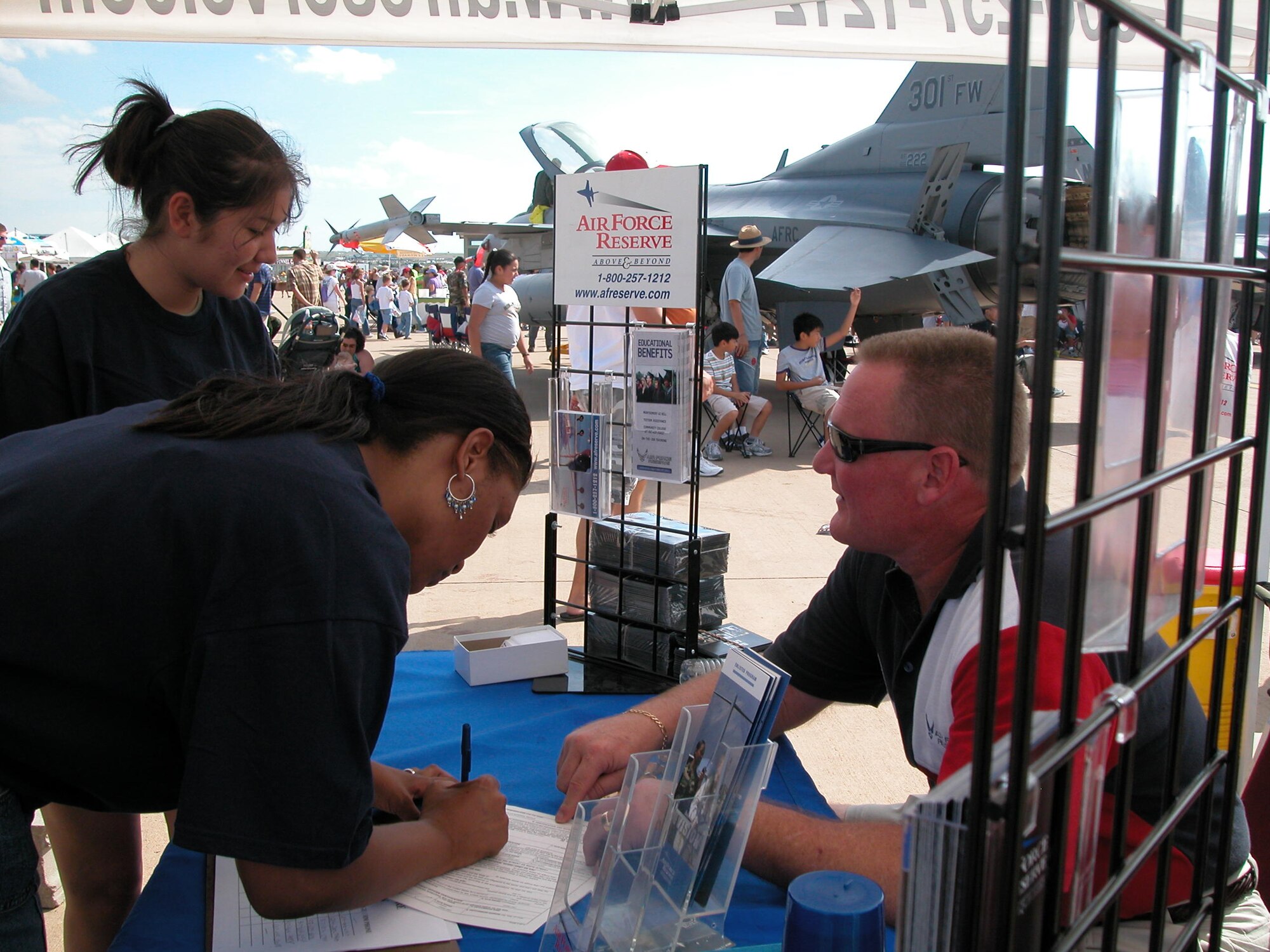 Master Sgt. John Shaffner, 301st Fighter Wing recruiter, helps two new Air Force Reserve recruits sign on the "dotted line" at this year's Alliance Air Show. There were six new 301st FW recruits there who took their oath of service with the famed Thunderbirds. U.S. Air Force Photo/Senior Master Sgt. Jeannine Pratt.