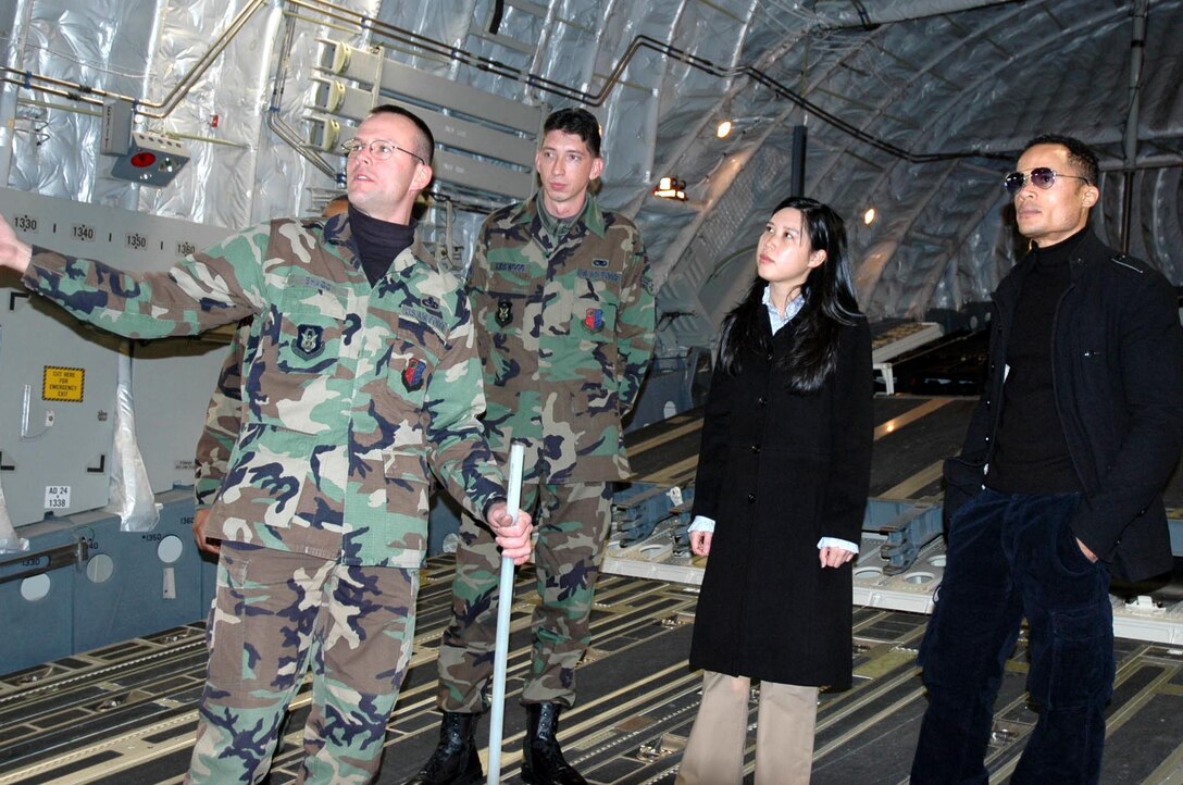 MCGUIRE AIR FORCE BASE, N.J. -- Air Force Reserve maintainers, Master Sgt. Corey Shagg and Airman 1st Class Ryan Kirkwood give Susan Chun, CNN producer and Jason Carroll, CNN national correspondent, a first-hand look at the C-17 Globemaster III, Dec. 6. The tour was part of their day-long media visit where they learned about McGuire's total force mission. (U.S. Air Force photo/Master Sgt. Donna T. Jeffries)