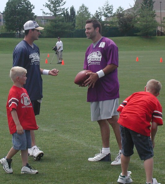 Marc Bulger (blue jersey) and Kurt Warner (purple jersey) meet the sons of Senior Master Sgt. Todd Wadkins, an Air Force Reservist from the 932nd Airlift Wing at Scott Air Force Base, Ill.  They spent time in between games playing catch with the kids out at Rams Park in St. Louis.  Photo/Capt. Stan Paregien