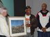 Frank McGinnley, an Air Force artist, presents George Watson, a Team McGuire member and original Tuskegee Airman, a painting depicting “The Great Train Robbery,” carried out by the Tuskegee Airmen in 1945. Also pictured is Mr. Watson’s grandson, George Watson III. U.S. Air Force photo by Senior Airman Dilia DeGrego