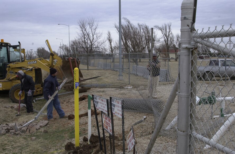 (Photo by MSgt George F. Jozens) Construction workers from LMC Construction Company of Tulsa, Okla, repair and install a part of the Vance perimeter fence.