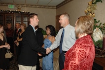 MINOT AIR FORCE BASE, N.D. -- Staff Sgt. Joseph Parise, 5th Bomb Wing protocol office, shakes hands with Chief Master Sgt. Mark Brejcha, 91st Space Wing command chief, during the annual Minot Air Force Base holiday party at the Jimmy Doolittle Center Dec. 2, 2006. (U.S. Air Force photo by Airman 1st Class Christopher Boitz)
