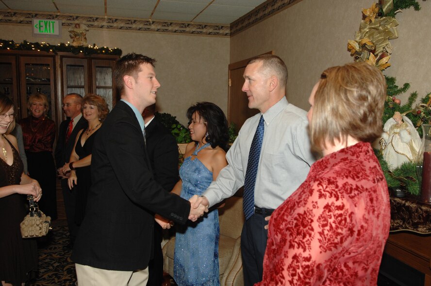 MINOT AIR FORCE BASE, N.D. -- Staff Sgt. Joseph Parise, 5th Bomb Wing protocol office, shakes hands with Chief Master Sgt. Mark Brejcha, 91st Space Wing command chief, during the annual Minot Air Force Base holiday party at the Jimmy Doolittle Center Dec. 2, 2006. (U.S. Air Force photo by Airman 1st Class Christopher Boitz)