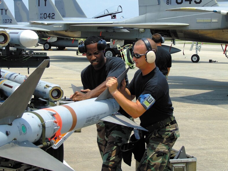 TYNDALL AIR FORCE BASE, Fla. --  Precision is key as Senior Airman Jason Barber, load crew member, and Staff Sgt. Michael Sirmons, support technician, install the fins on an AIM-7 missile before loading it onto an F-15 Eagle. Both Airmen are with the 325th Aircraft Maintenance Squadron here. (U.S. Air Force photo by Staff Sgt. Edward Gyokeres)