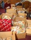 MINOT AIR FORCE BASE, N.D. -- Members from both the Minot Officers Spouses Club and the Minot Enlisted Spouses Club wrap up home-baked goods during the annual Airman’s Cookie Drive at the Northern Lights Chapel Dec. 6, 2006. Each Airman living in the dormitories will receive a gift-package of baked goods. (U.S. Air Force photo by Airman 1st Class Joe Rivera)