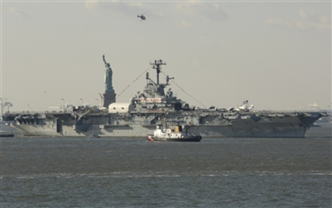 Retired USS Intrepid approaches the Statue of Liberty in New York Harbor, N.Y., Dec. 5, 2006, on its way to Bayonne, N.J., for two years of maintenance. The Intrepid has served in World War II, Korea and Vietnam and is now a museum at Pier 86 in New York City.  