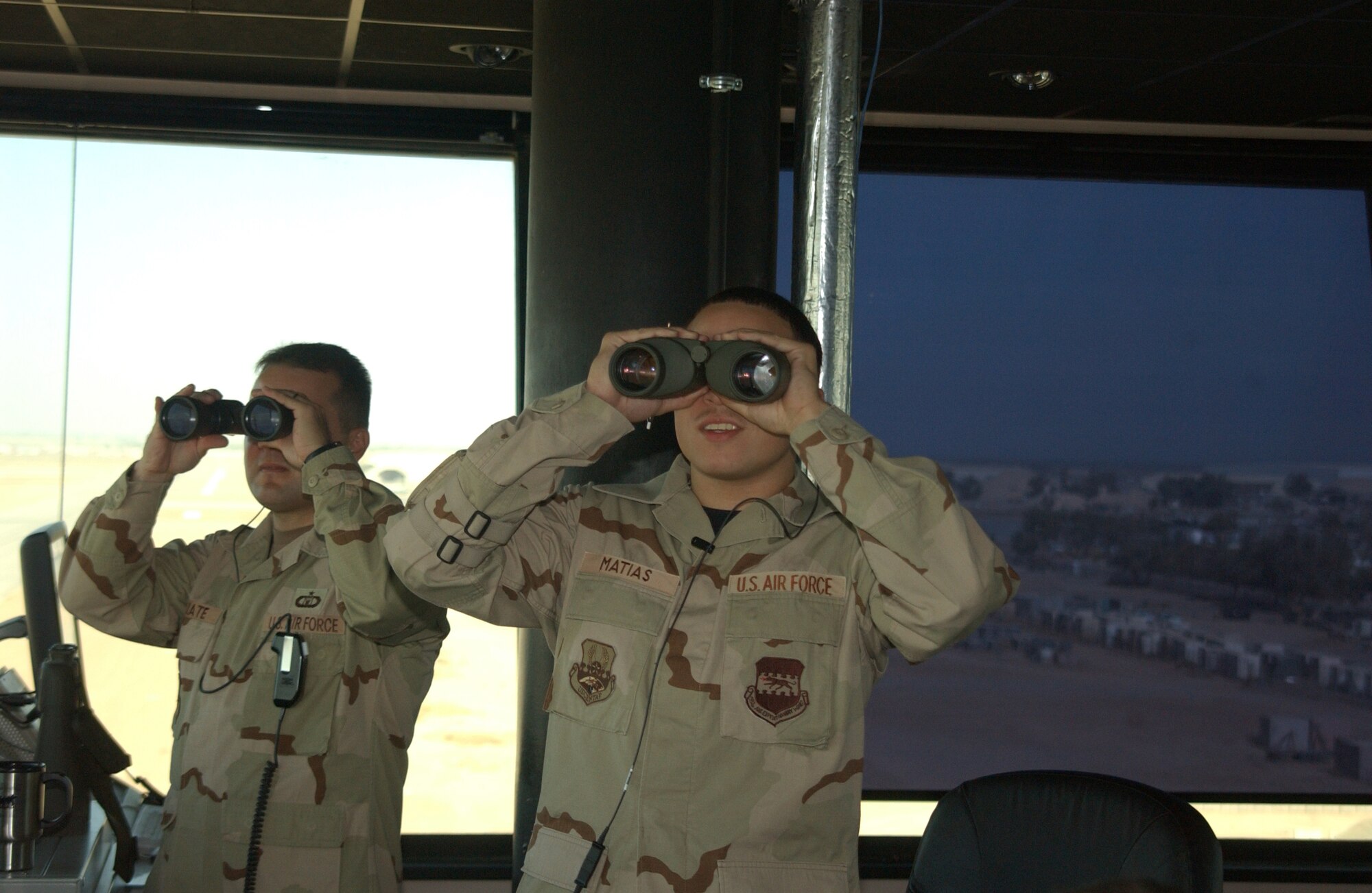 BALAD AIR BASE, Iraq -- Senior Airman Joshua Matias (right), 332nd Expeditionary Operations Support Squadron air traffic control apprentice, scans the Balad Air Base flightline Tuesday. Airman Matias was recognized with the 2006 Air Traffic Control Association Lingiam Odems Memorial Award. (U.S. Air Force photo by Senior Airman Josh Moshier)