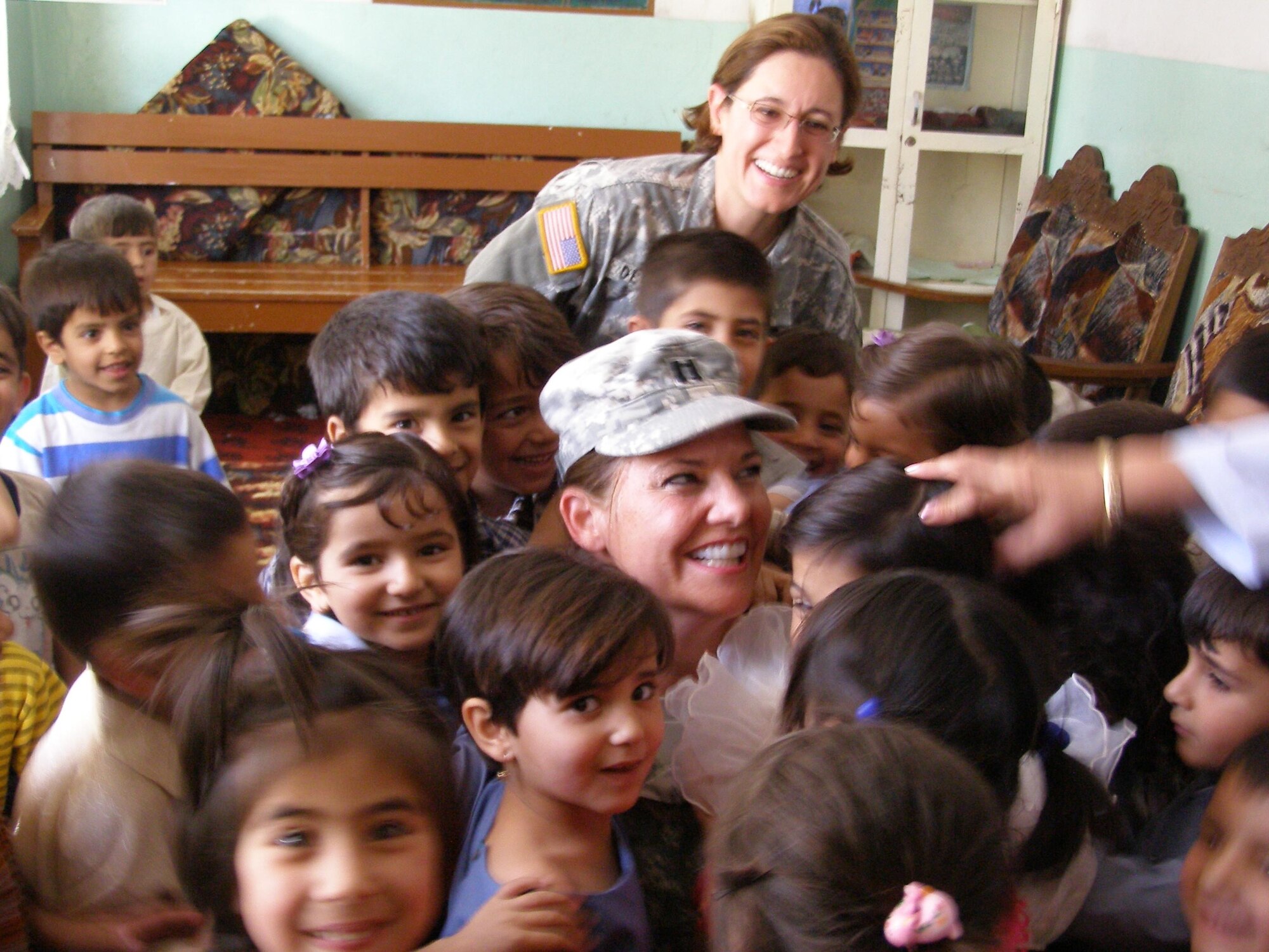 SOUTHWEST ASIA --  Capt. Karen Kramer (center), from the 325th Medical Group, visits an orphanage while deployed here. (U.S. Army photo by Master Sgt. Traci Williams)