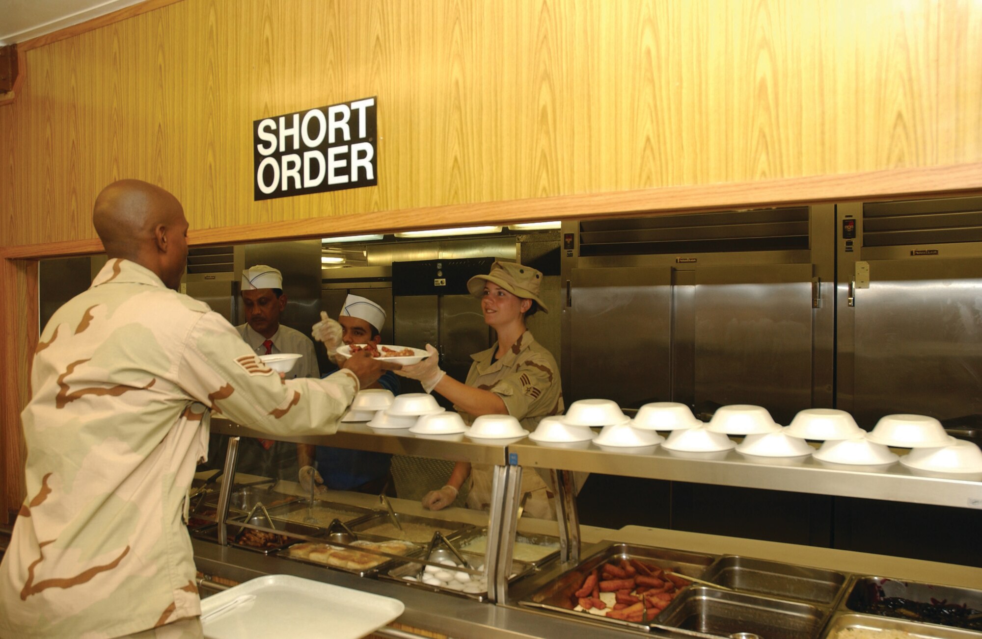 SOUTHWEST ASIA --  Senior Airman Carol Hysell, from the 325th Services Squadron, serves food while deployed to Al Udeid Air Base. (Courtesy photo)