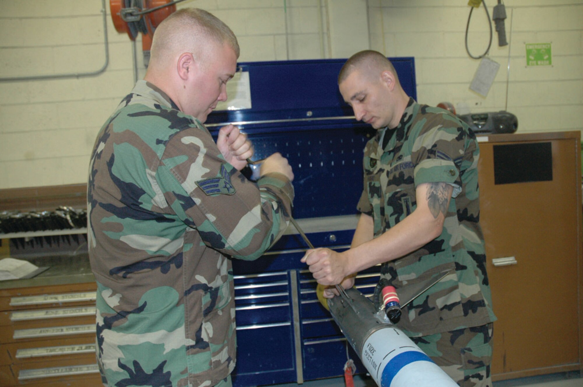 TYNDALL AIR FORCE BASE, Fla. --  Senior Airmen Christopher Bratcher (left) and Jeffrey Hird, both precision guided munitions shop crew members, remove the fins from the guidance control section of a captive air training missile (CATM-9) prior to performing maintenance. (U.S. Air Force photo by Staff Sgt. Stacey Haga)