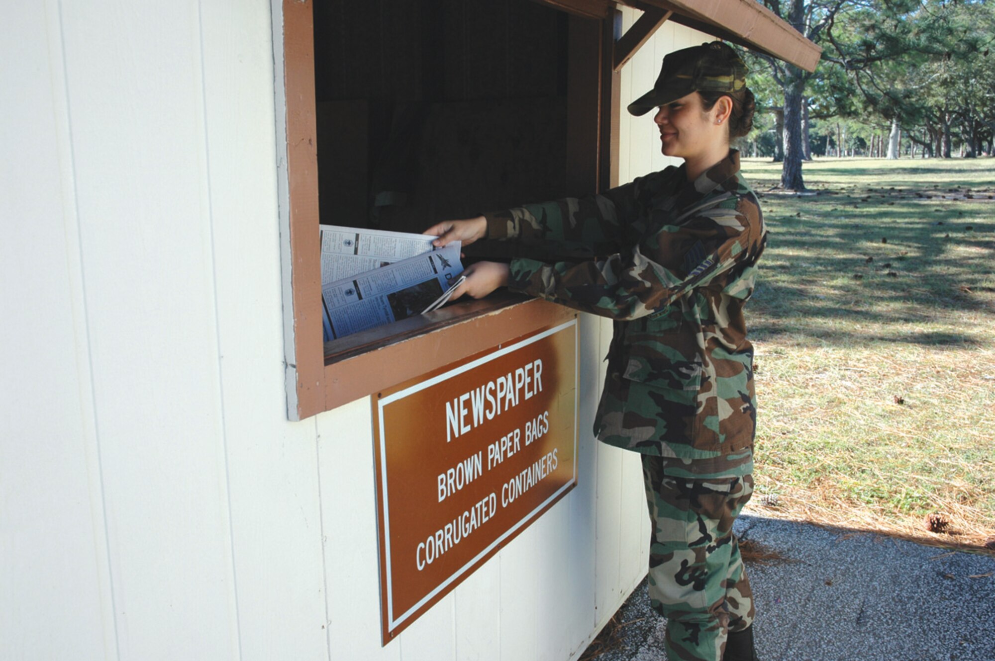 TYNDALL AIR FORCE BASE, Fla. --  Staff Sgt. Melissa Johnson, 325th Fighter Wing, recycles the Gulf Defender after reading it. Paper products such as newspaper, magazines and phone books are all deposited in the newspaper bins. The center requests magazines and similar items be bagged seperate from other paper items for easier sorting. (U.S. Air Force photo by Staff Sgt. Stacey Haga)