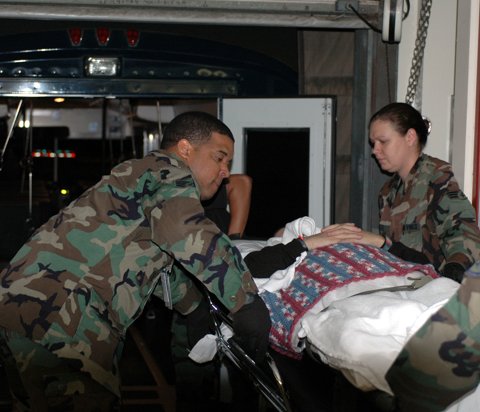 Staff Sgt. Kristopher Bradley and Senior Airmen Heather Ducote, 60th Aerospace Medical Squadron medical technicians, transfers a patient from ambulance bus to the unloading arrival/departure lounge. (U.S. Air Force photo by Staff Sgt. Matt McGovern/60th Air Mobility Wing Public Affairs)