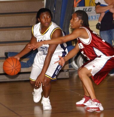 Joseph, left, drives around Faulkner State’s LaToya Brown. Jospeh’s three-point shot sent the game into overtime. (U.S. Air Force photo by Kemberly Groue)
