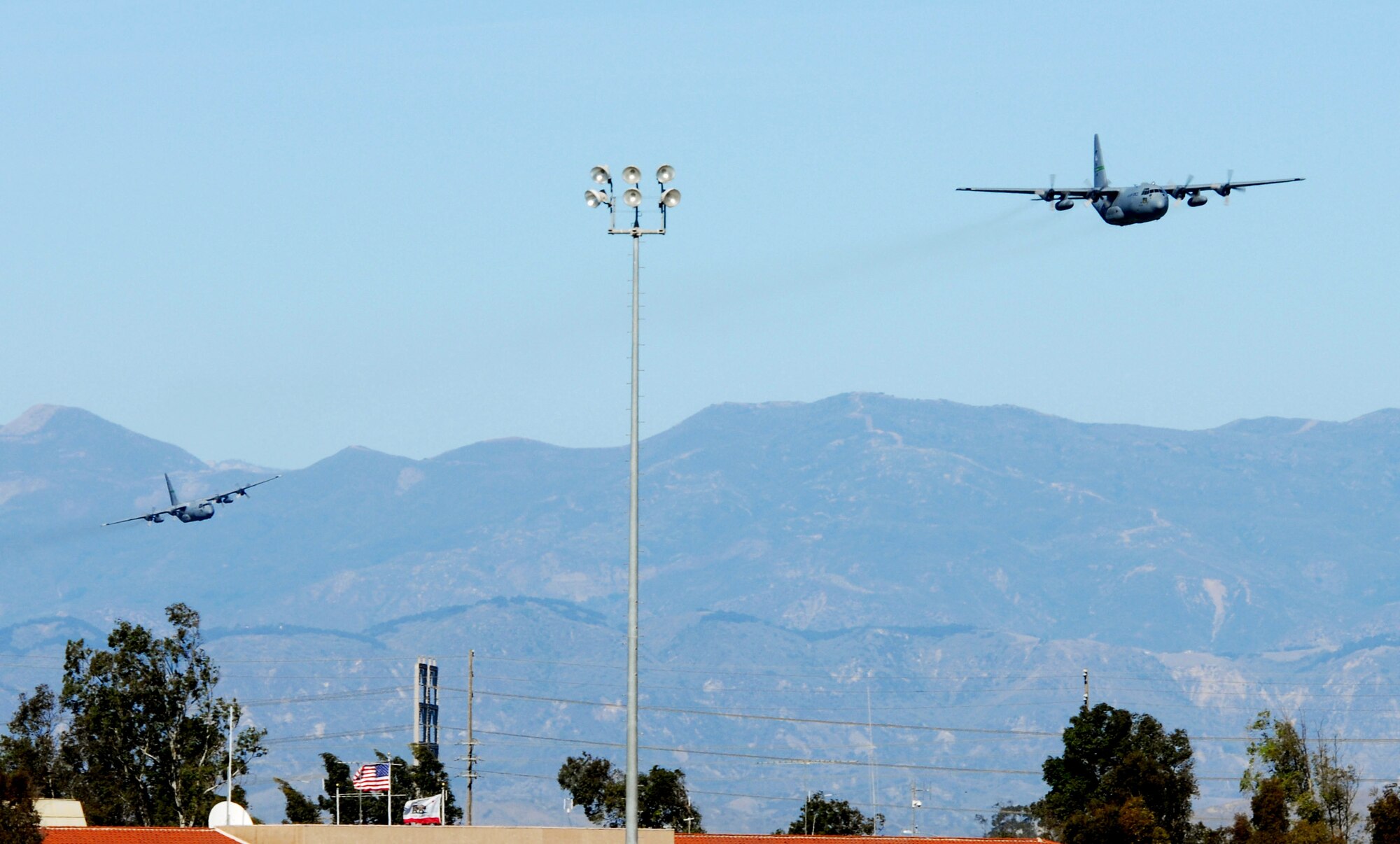 Two C-130 Hercules from the 146th Airlift Wing fly Dec. 2 over Channel Island Air National Guard Station in California for the last time. Air National Guard flew their last two Hercules E for the final time. The aircraft were delivered to the Air Force in the early 1960's and came to the 146th in 1974. They served in many ways including bringing in relief supplies and tranporting injured citizens natural disasters, most recently Huricane Katrina. The wing's C-130s were also capable of delivering fire retardant to help fight wildfires. (U.S. Air Force photo/Tech. Sgt. Dave Buttner)
