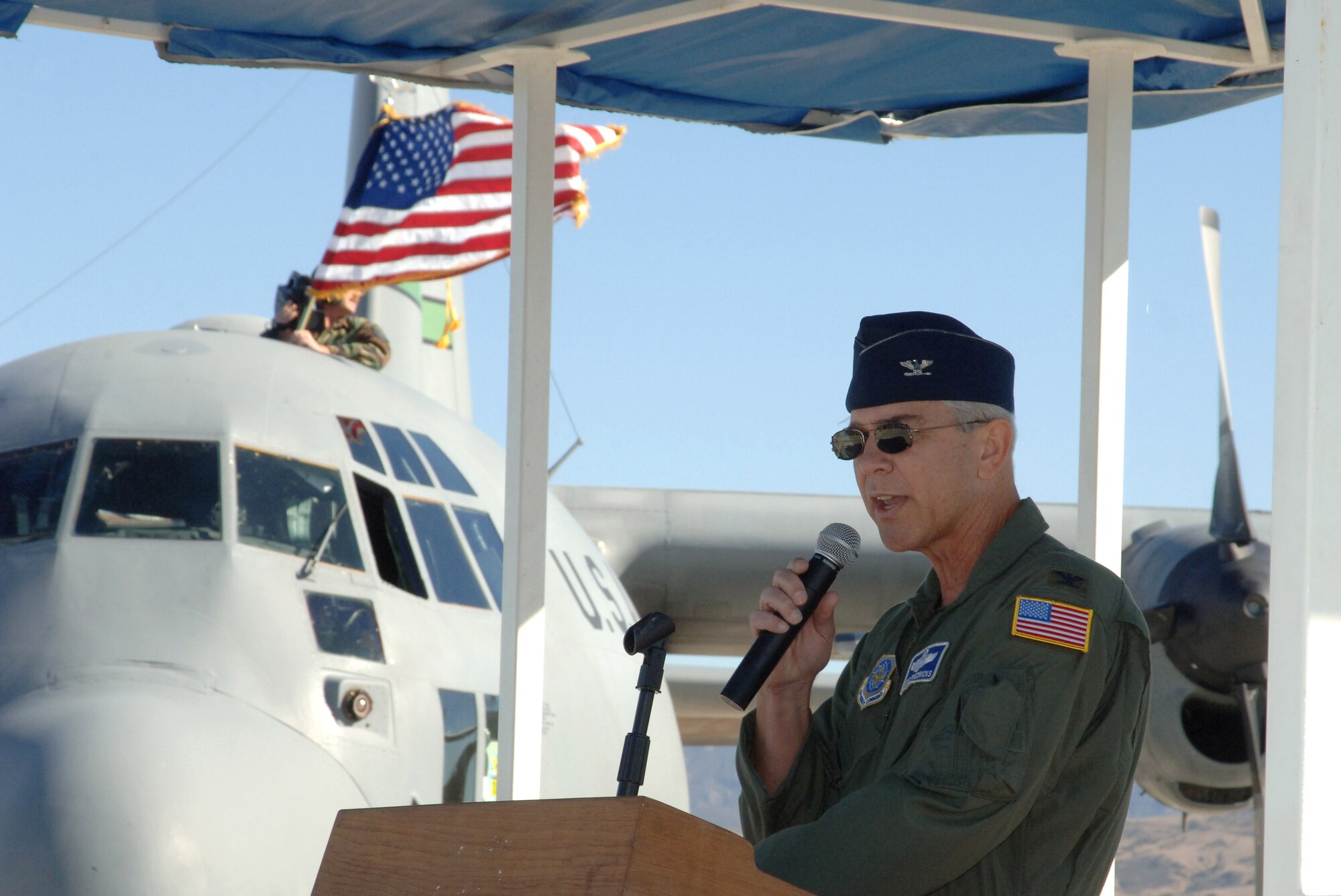 Col. Stephen Friederick speaks to a crowd Dec. 2 gathered on the flightline at Channel Island Air National Guard Station in California. Airmen from the 146th Airlift Wing flew their last two C 130 Hercules for the final time. The aircraft were delivered to the Air Force in the early 1960's and came to the 146th in 1974. They served in many ways including bringing in relief supplies and tranporting injured citizens natural disasters, most recently Huricane Katrina. The wing's C-130s were also capable of delivering fire retardant to help fight wildfires. Colonel Friederick is the 146th AW commander. (U.S. Air Force photo/Master Sgt. Rodney Thornburg)