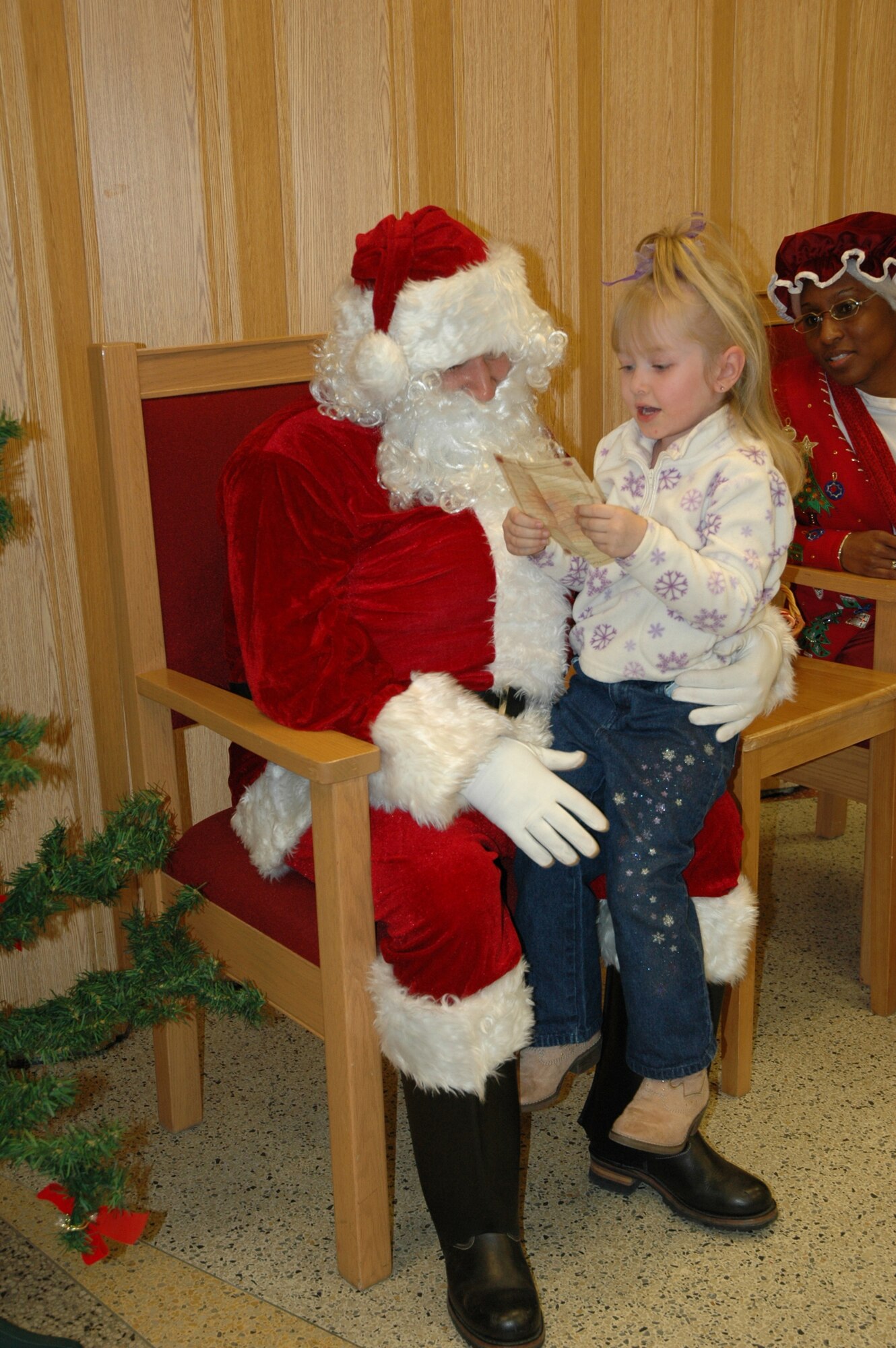 Ivory Boggs, 4, reads her Christmas list to Santa Claus Dec. 7 at the Base Chapel following the base tree lighting ceremony. (U.S. Air Force photo by Steve Brady)