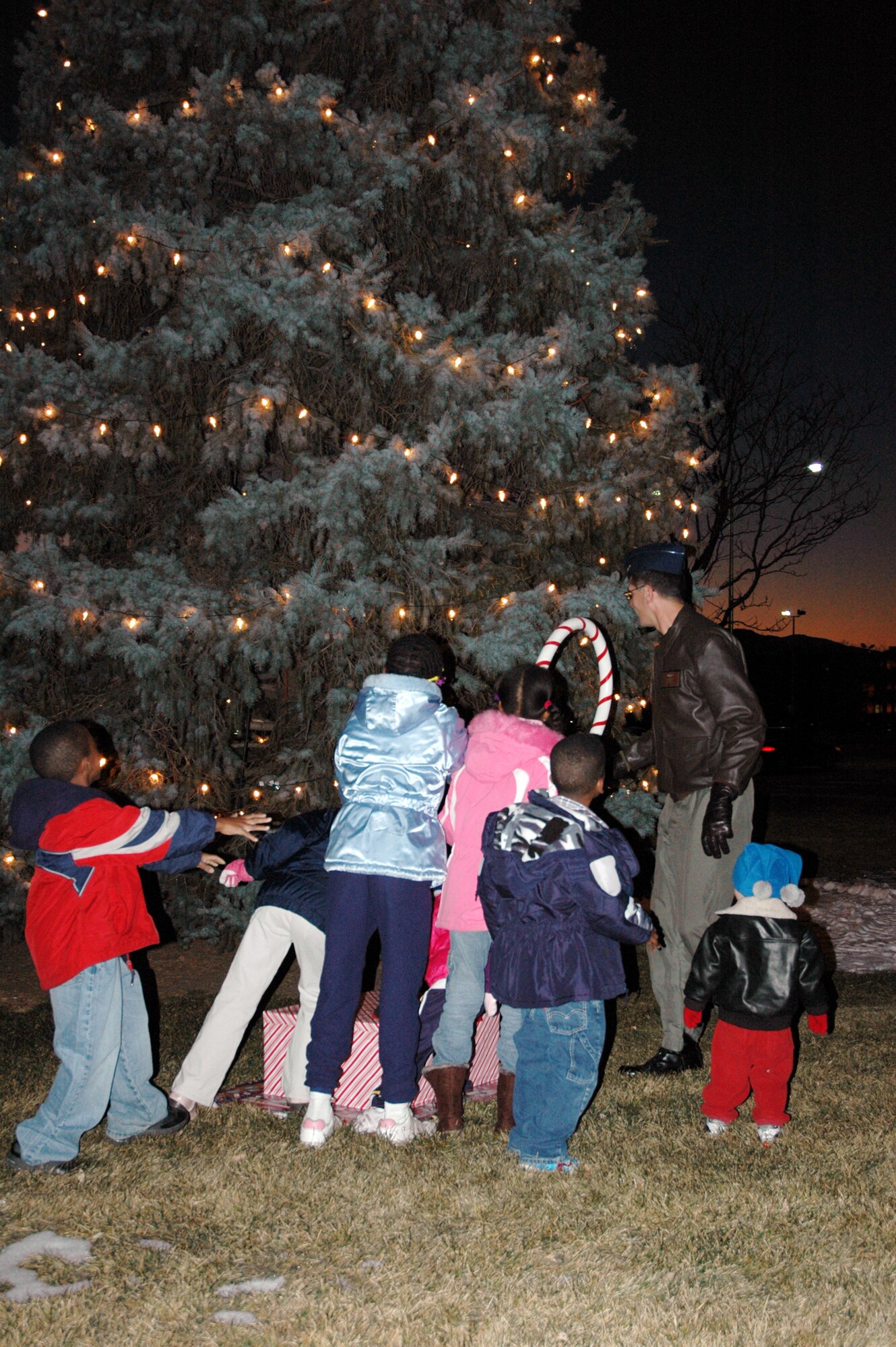A group of children help Col. Jay G. Santee, 21st Space Wing commander, light the base Christmas tree Dec. 7 at the Base Chapel. The evening included caroling, hot chocolate and cookies, and a visit by St. Nick. (U. S Air Force photo by Steve Brady)