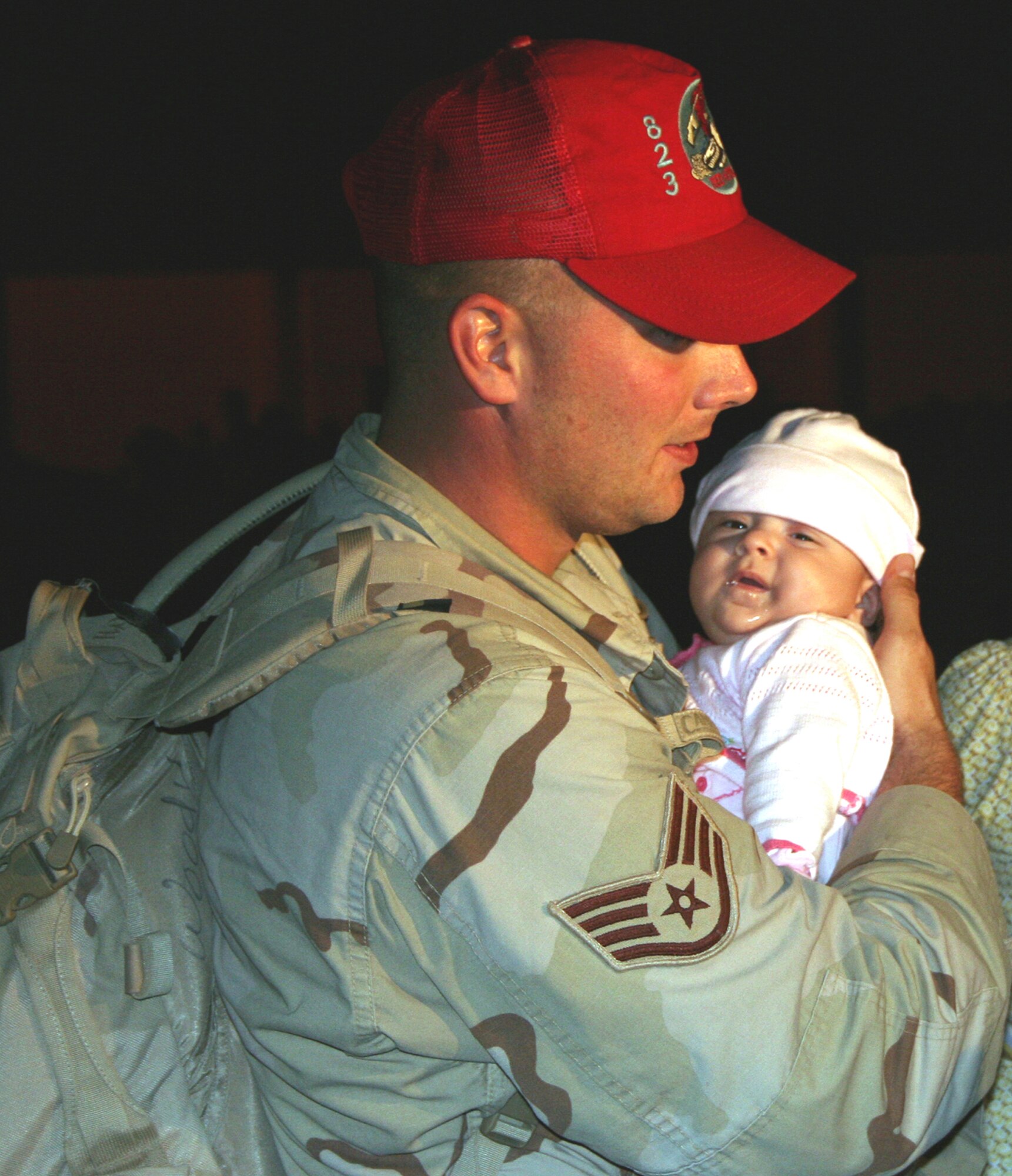 Staff Sgt. Brandon Woodward, 823rd RED HORSE Squadron, holds his daughter, Isabella, who was born in September, for the first time after returning home to Hurlburt Field from a 7-month deployment Wednesday. (U.S. Air Force Photograph by 2nd Lt. Lauren Johnson)