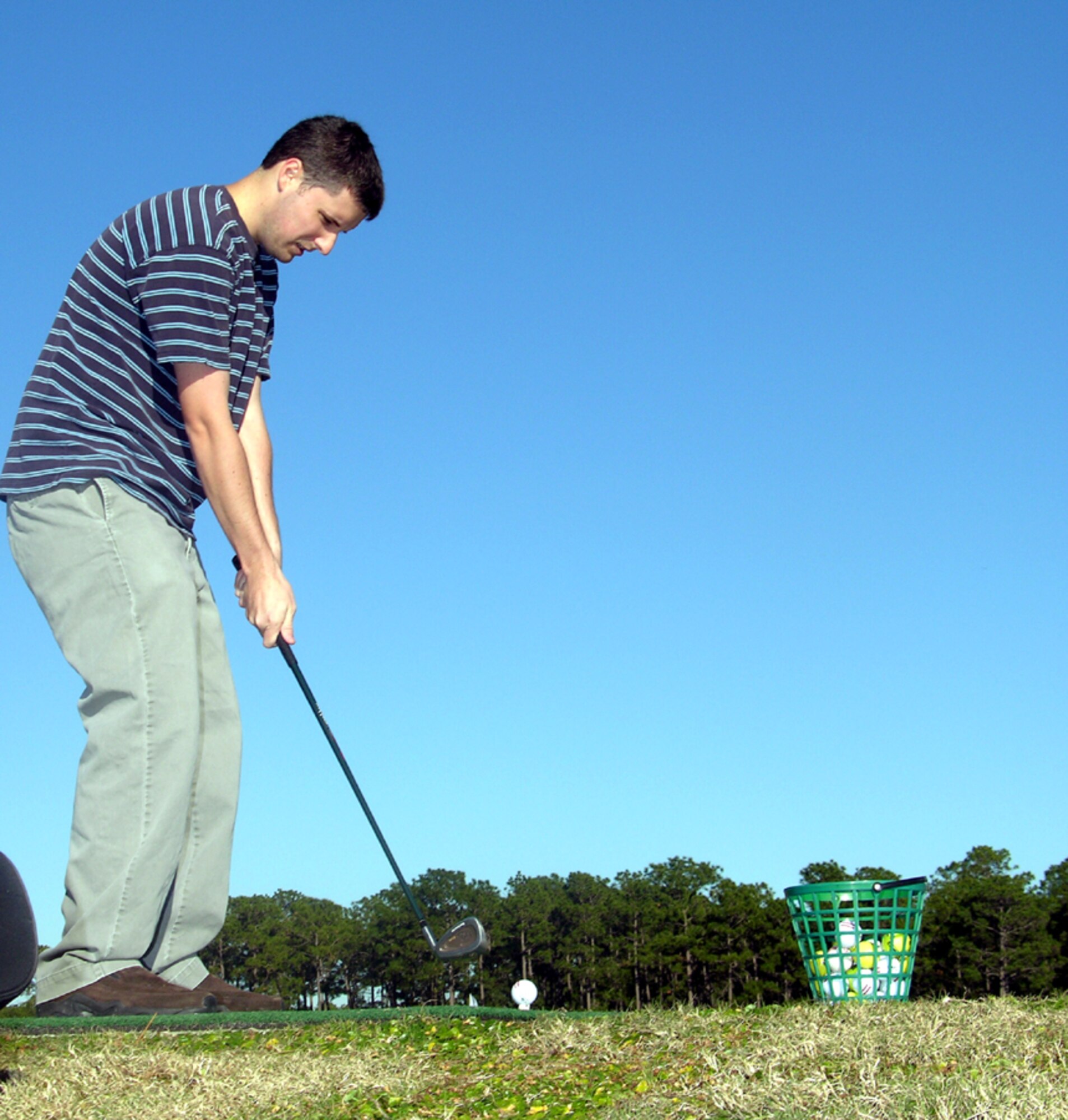 Senior Airman Nathaniel Starr, 1st Special Operations Helicopter Maintenance Squadron, practices hitting a few balls at the Gator Lakes driving range Dec. 4. The Gator Lakes Golf Course reopened recently after months of renovations. (U.S. Air Force Photograph by Jon Ortiz)