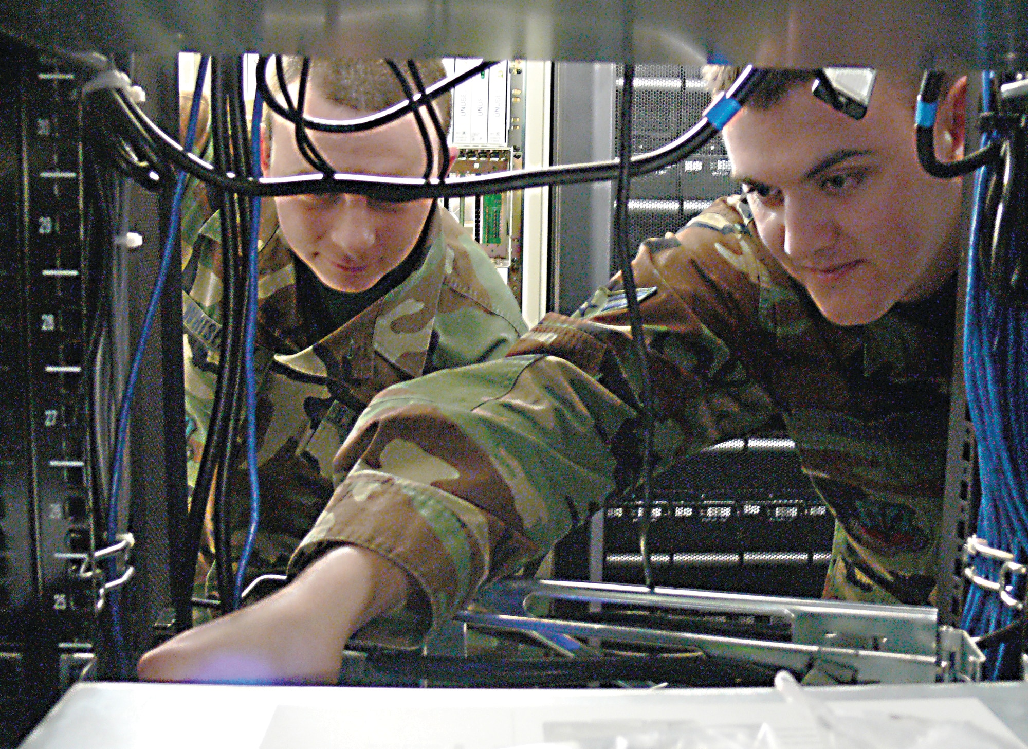 Airman 1st Class Keith Arnolts, 23rd Communication Squadron exchange administrator (right), and Staff Sgt. Zach Whisenant, 23rd CS network administrator, ensure the power is connected properly on a network server at the 23rd CS Network Control Center recently.  The 23rd CS is currently migrating the Moody computer networks to Air Combat Command, providing rare training for the squadron’s Airmen. (U.S. Air Force photo by Senior Airman S.I. Fielder)