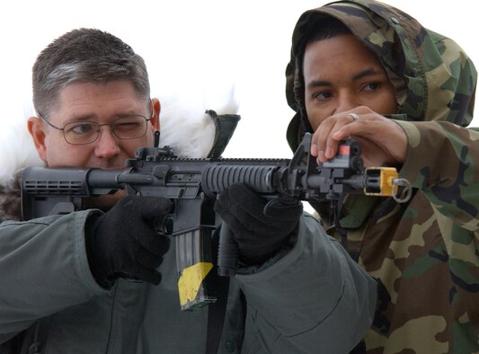 Staff Sergeant Robert Cook, 341st Security Support Squadron, adjusts the Beam Hit laser on the M-4 being used by Chief Master Sgt. Michael Sullivan, Air Force Space Command command chief, during a demontration at building 219 Dec. 1
