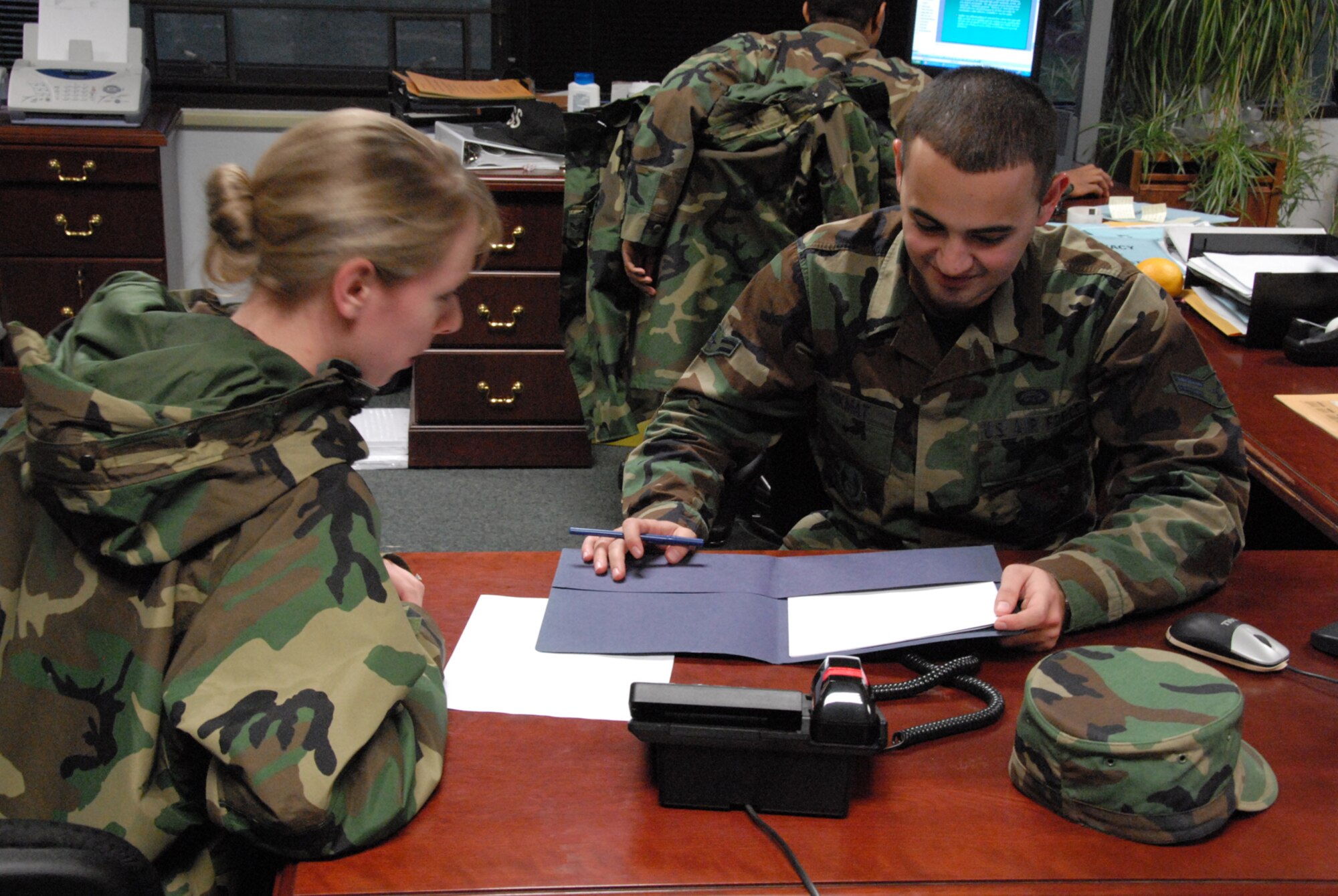Airman 1st Class Zana Hikmat, 66th Mission Support Squadron personnelist, assists 1st Lt. Martha Petersante-Gioia, 66th Air Base Wing Public Affairs, with paperwork. (US Air Force Photo by Airman 1st Class Clinton Atkins)
