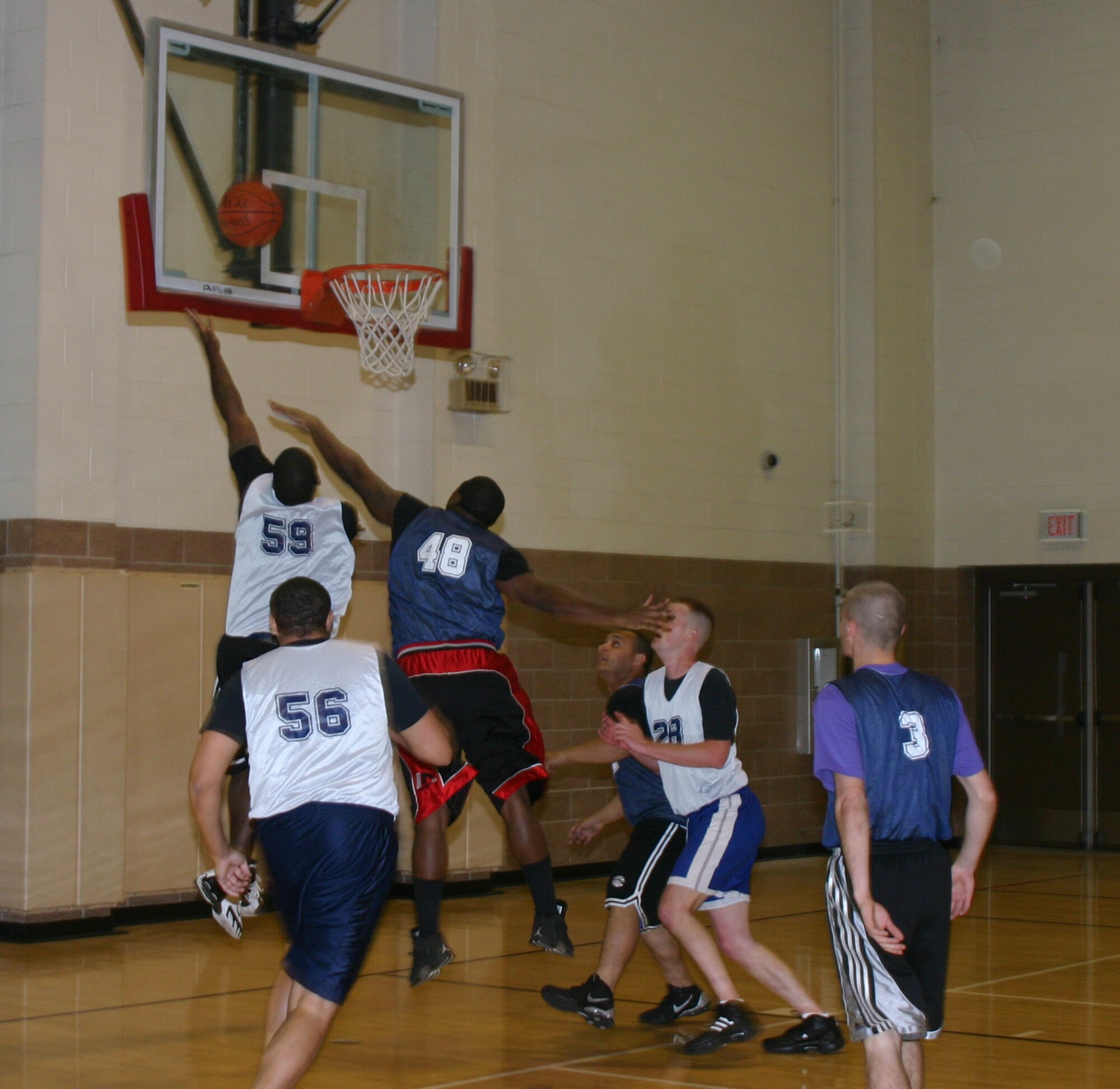 Members of the 82nd Security Forces Squadron Cops and the 82nd Communications Squadron intramural basketball teams jump for a rebound in their game Tuesday night at the Levitow Fitness Center. (U.S. Air Force photo/Airman Jacob Corbin.)