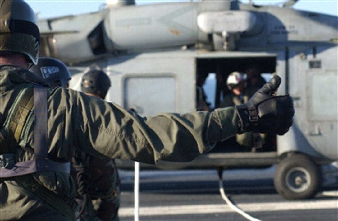 Sailors assigned to Explosive Ordnance Disposal Mobile Unit 11, Detachment Northwest, participate in special purpose insertion and extraction exercise during helicopter rope suspension techniques master qualifications on the flight deck aboard the nuclear-powered aircraft carrier USS Nimitz, in the Pacific Ocean, Dec. 5, 2006.