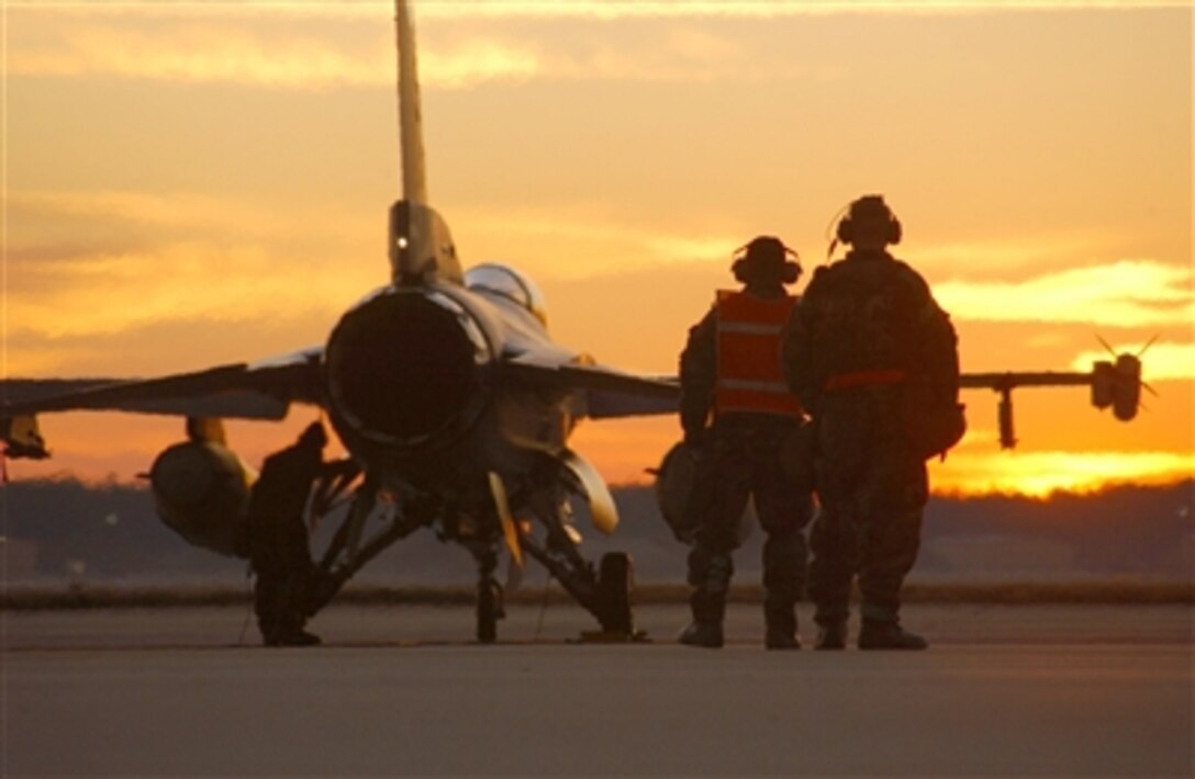 U.S. Air Force Tech. Sgt. Aubrey Dickerson and Master Sgt. Tracey Shook prepare to launch an F-16 Fighting Falcon on a sortie in support of a Phase 2 exercise Dec. 6 at Shaw Air Force Base, S.C. The war-like exercise prepares airmen for deployments. 