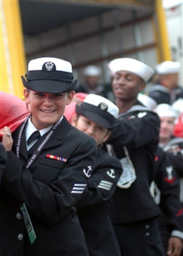 U.S. Navy Seaman Danielle Kalish (left) and other sailors carry the national ensign into Alltel Stadium prior to the NCAA Atlantic Coast Conference championship game in Jacksonville, Fla., on Dec. 2, 2006.  More then a hundred sailors from the USS John F. Kennedy (CV 67) presented the ensign during the pre-game playing of the national anthem.  