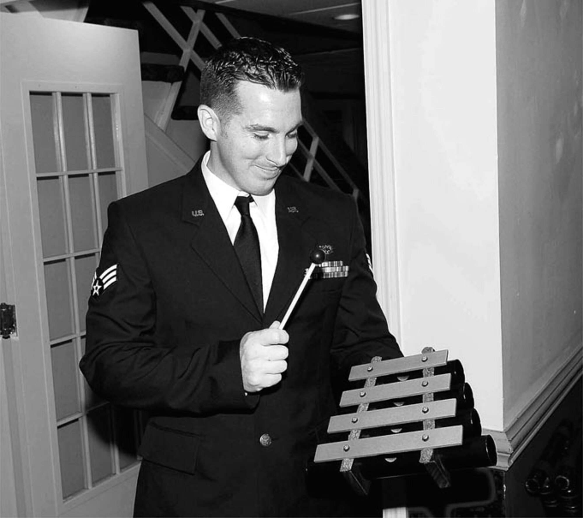 Senior Airman Christopher Mooney, 23rd Aircraft Maintenance Squadron, rings the dinner chimes at the Airman Leadership School graduation Oct. 26. 