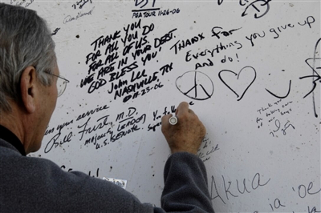 Defense Secretary Donald H. Rumsfeld signs the wall outside the Air Force Theatre Hospital at Balad Air Base, Iraq, Dec. 9, 2006. The message read, "You fellows are superstars." Rumsfeld made a surprise visit to Iraq to thank the troops and their families for their sacrifice and service to the country.
