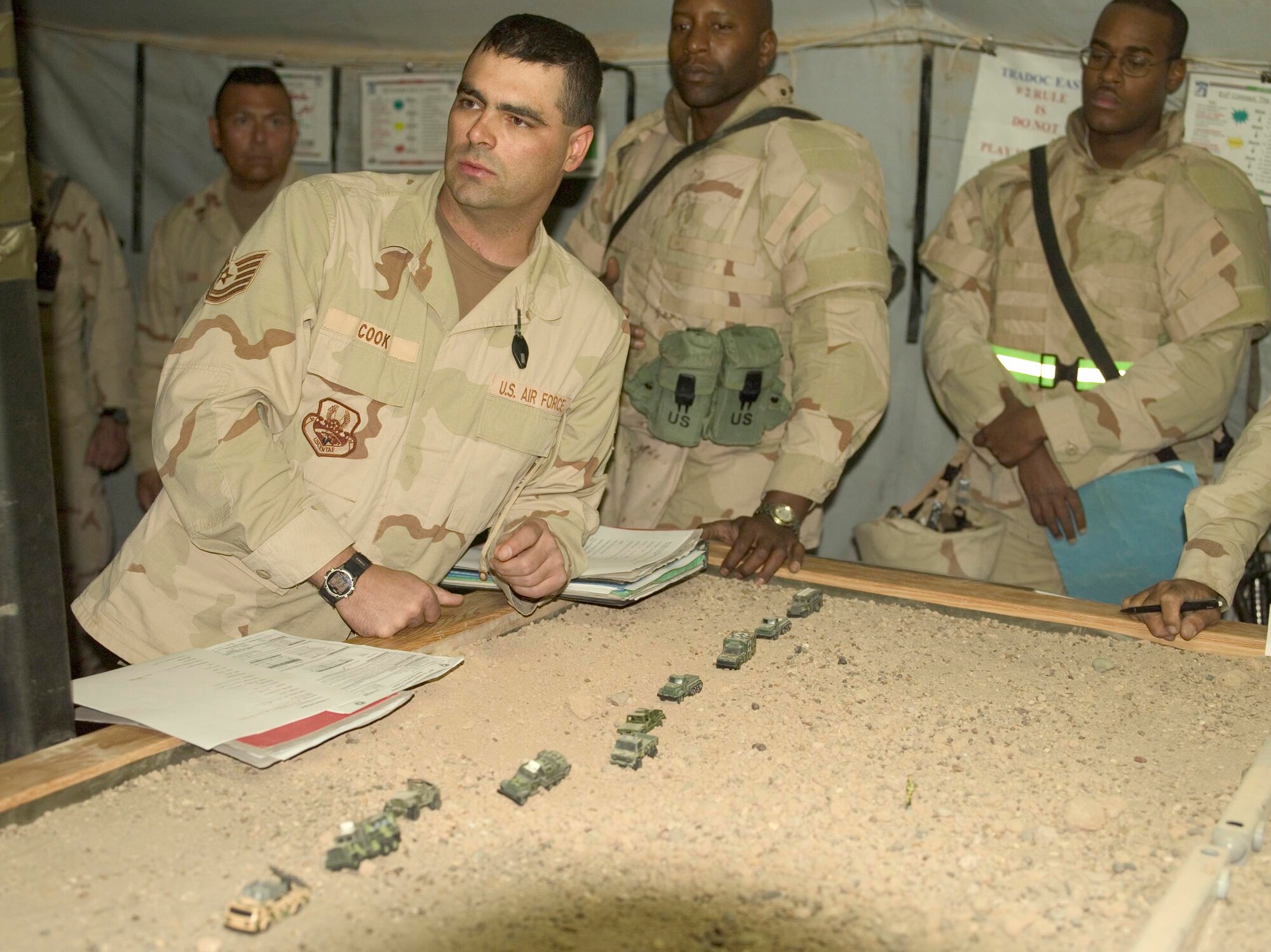 Tech. Sgt. Jason Cook gives a convoy briefing to members of the Army while deployed to Iraq from July 2005 to February 2006. Toy cars were used to represent the convoy as Sergeant Cook went through battle drills on a sand table. Sergeant Cook, 90th Logistics Readiness Squadron vehicle operations supervisor, earned teh Bronze Star for meritorious service in Iraq, and was presented teh medal by Col. Michael Morgan, 90th Space Wing vice commander.