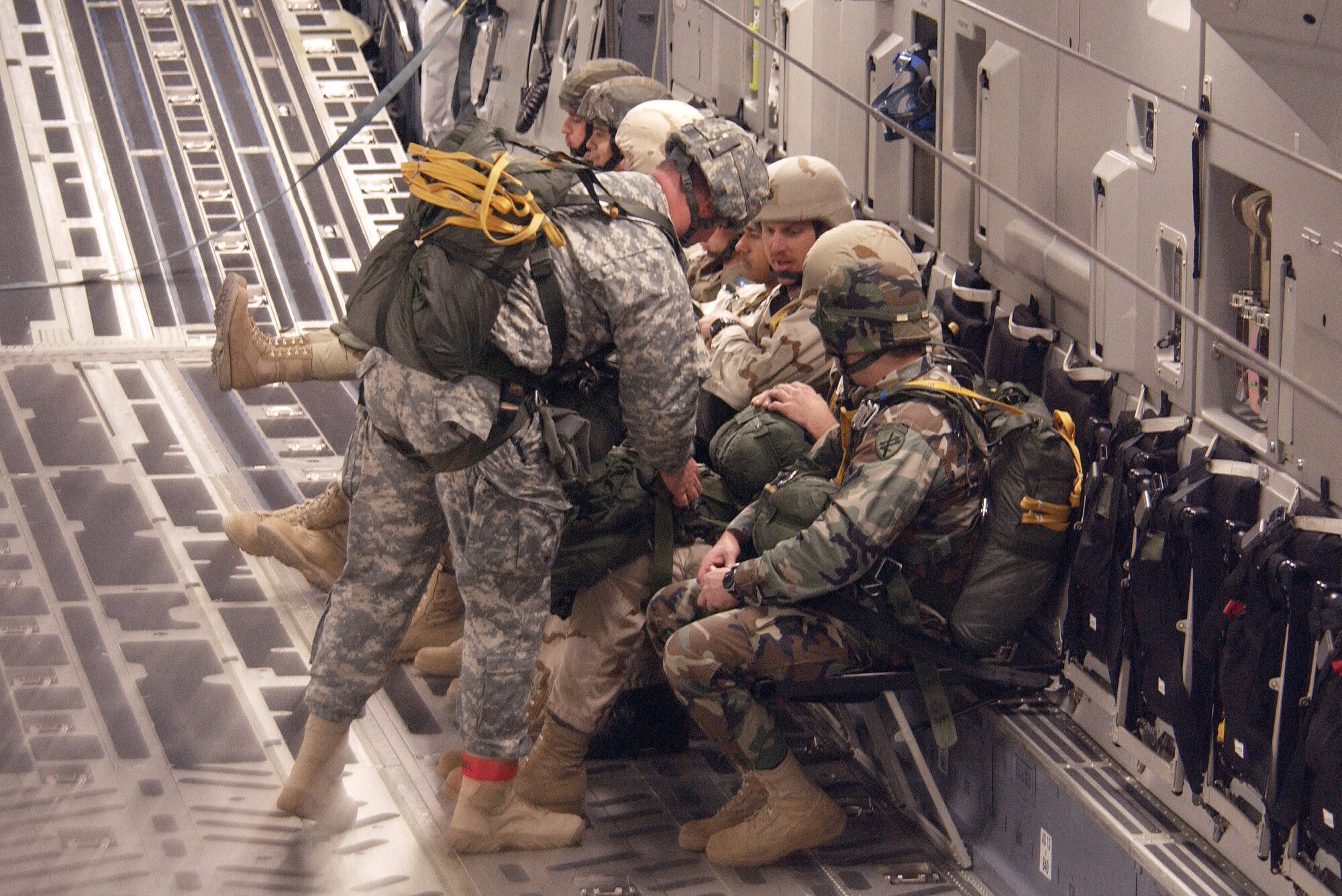 Members of the 820th Red Horse Squadron prepare jump gear with along with Army Airborne members before a landing zone exercise during the Weapon School's Mission Employment Phase Dec. 8 at Nellis Air Force Base, Nev. Mission employment is the final phase of a five-month course prior to weapons school graduation. Nearly 80 aircraft from both the Air Force and Navy will participate in the nearly two-week event.  (U.S. Air Force photo/Master. Sgt. Kevin J. Gruenwald)      
