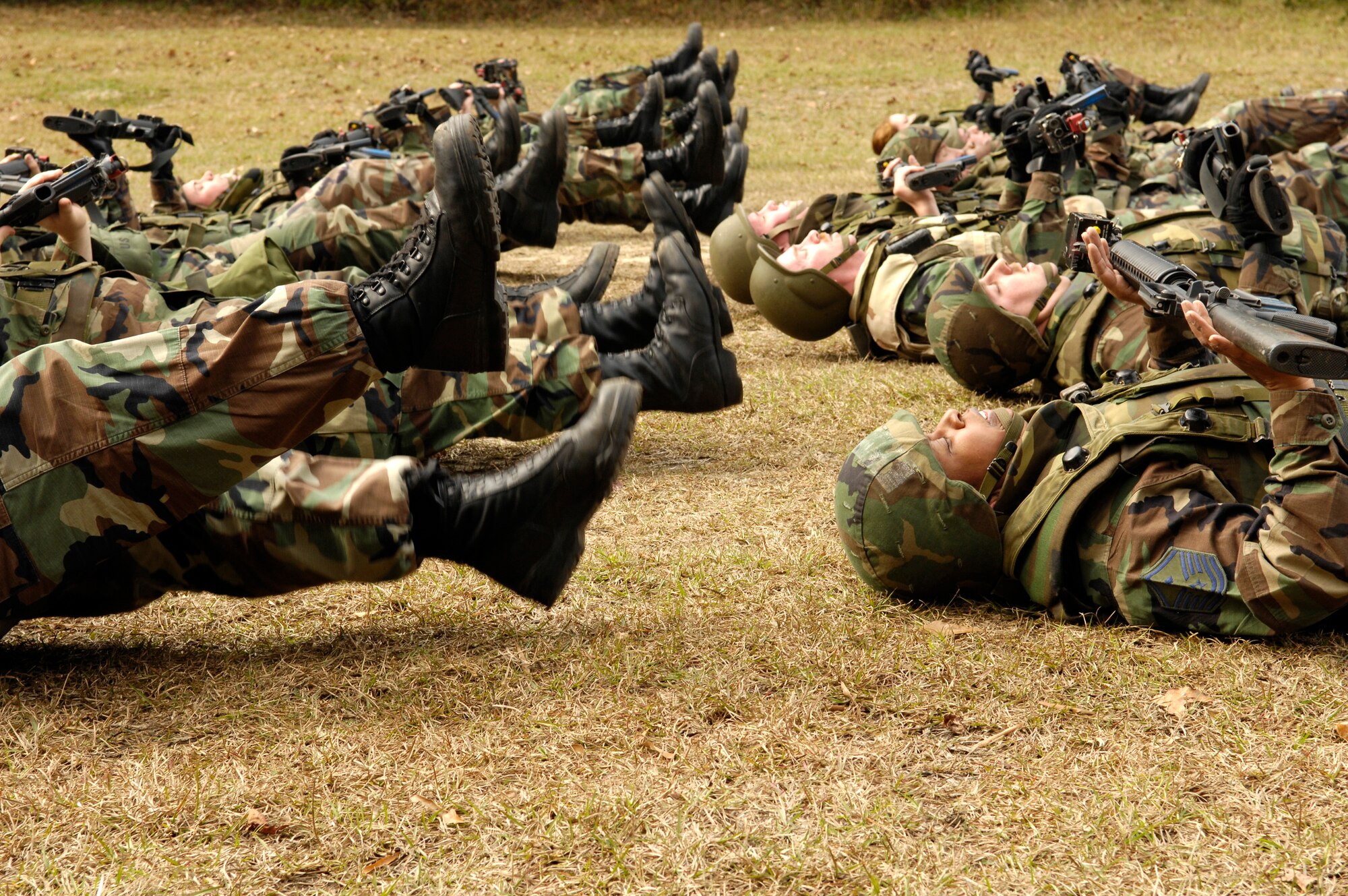 Airmen exercise flutter kicks as they hold their weapons up in the air during the Expeditionary Combat Skills Training Dec. 7 at Charleston Air Force Base, S.C., The ECST is a three-day tactical operations course to prepare members of the 437th Airlift Wing for deployment. (U.S. Air Force photo/ Senior Airman Desiree N. Palacios)
