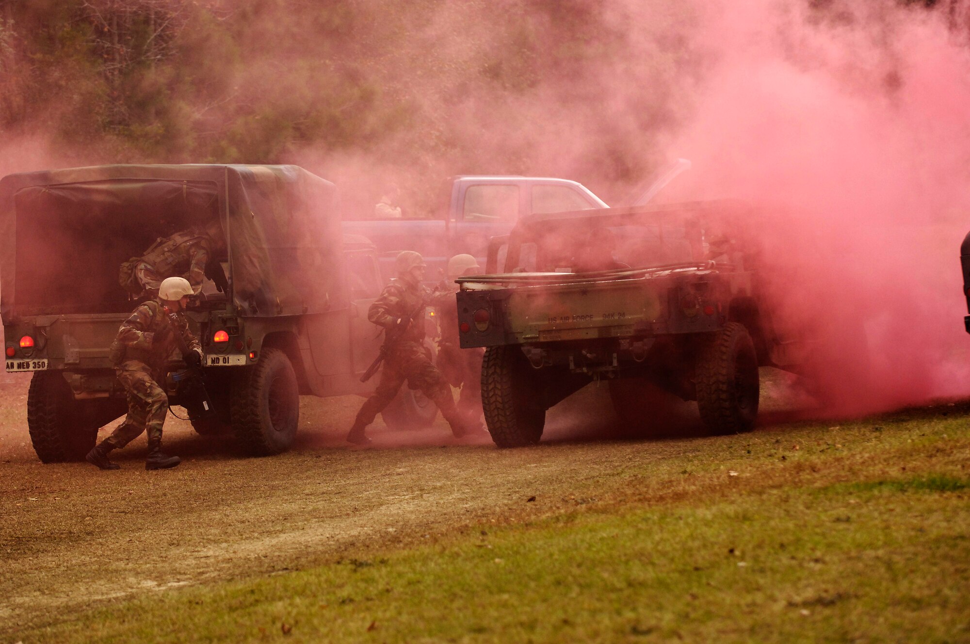 Members of the 437th Airlift Wing cross load through smoke after a vehicle in their convoy was struck by a simulated improvised explosive device during the Expeditionary Combat Skills Training Dec. 7 at Charleston Air Force Base, S.C. The ECST is a three-day tactical operations course to prepare Charleston Airmen for future deployments. (U.S. Air Force photo/Senior Airman Desiree N. Palacios)