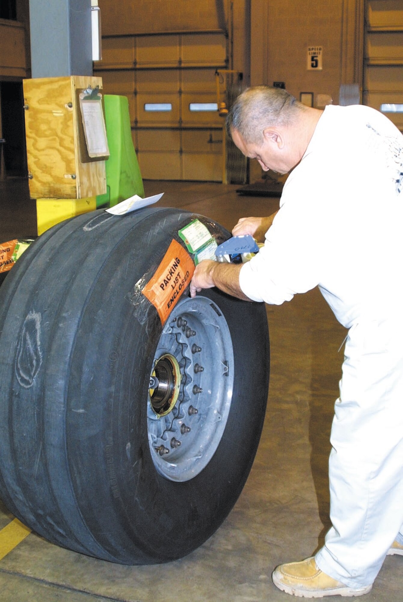 Raimundo Lugo prepares a C-17 tire for shipping.