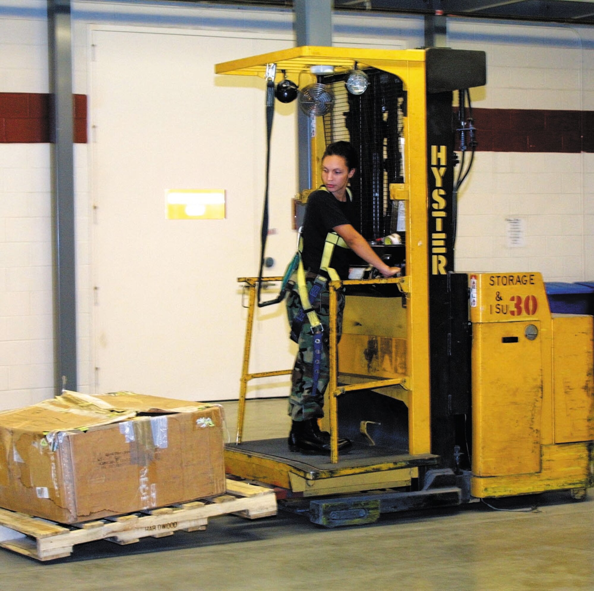 Staff Sgt. Nickola King operates the Hyster as she moves pallets to a new location.