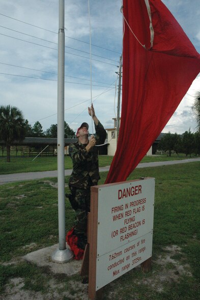 TYNDALL AIR FORCE BASE, Fla. --  Staff Sgt. Brasndon Binczak, 325th Security Forces Squadron combat arms instructor, raises the red flag in front of the range before M-9 training Monday morning. The red flag serves as a reminder to personnel driving or walking by that live fire is on the range. No one is allowed to go behind the range at this time. (U.S. Air Force photo by Chrissy Cuttita)