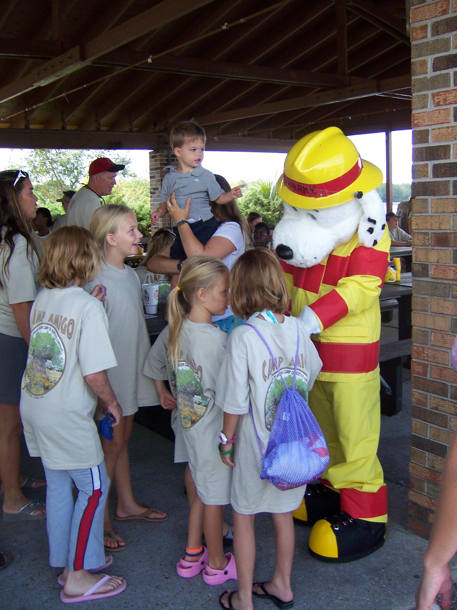 TYNDALL AIR FORCE BASE, Fla. --  Airman 1st Class Robert Perricone, 325th Civil Engineer Squadron firefighter, dressed as "Sparky the Dog," greets children at Bonita Bay. Members of the Tyndall Fire and Emergency Services spent time July 12 with children from Camp Amigo, a summer camp for kids ages 6 to 18 who are burn survivors. The program is run by firefighters, burn-unit nurses and adult burn survivors. The camp's mission is to provide kids who have physical and emotional scars with a place to be themselves and build a network of support that will last throughout their lives. (U.S. Air Force photo by Michael Newberry)