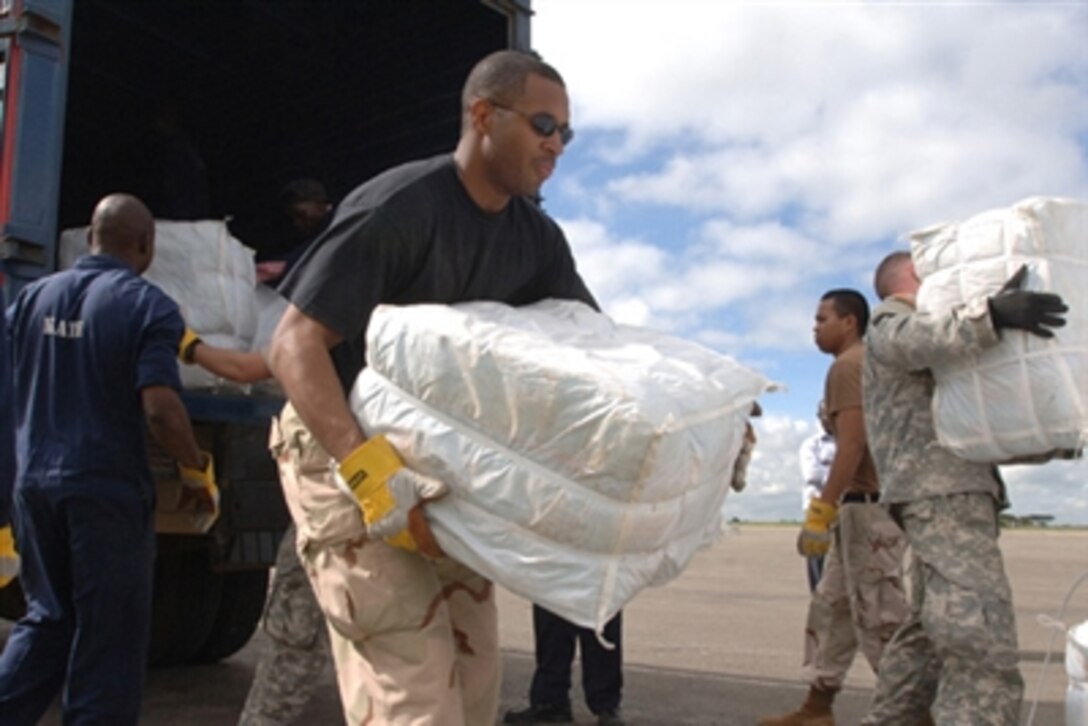 U. S. Air Force Staff Sgt. Shawn Stewart of Norfolk, Va., helps Kenyan workers and U.S. Army servicemembers assigned to Combined Joint Task Force -- Horn of Africa in unloading mosquito nets for victims of severe flooding in the Dadaab region of Kenya, Dec. 9, 2006.
