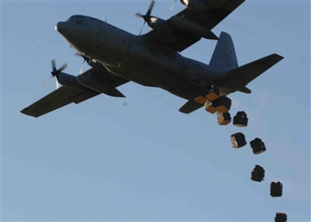 A U.S. Air Force C-130 Hercules aircraft drops bundles of shelters and mosquito nets onto a field in Dadaab, Kenya, Dec. 10, 2006. 