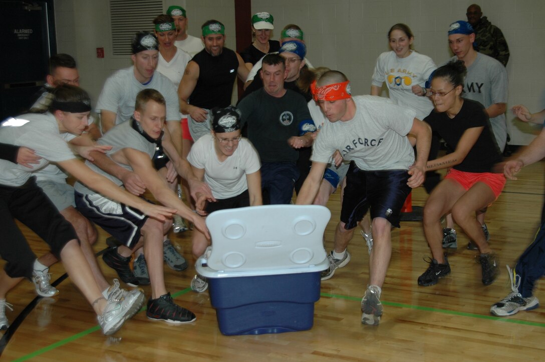 Participants in the Survival Fitness event, held Dec. 7 at the Bellamy Fitness Center, race towards the cooler to grab a frozen t-shirt. The participants had to thaw the t-shirt out enough to be able to put it on and race around the track to complete this portion of the event. (Photo by Airman Nathan Riley)