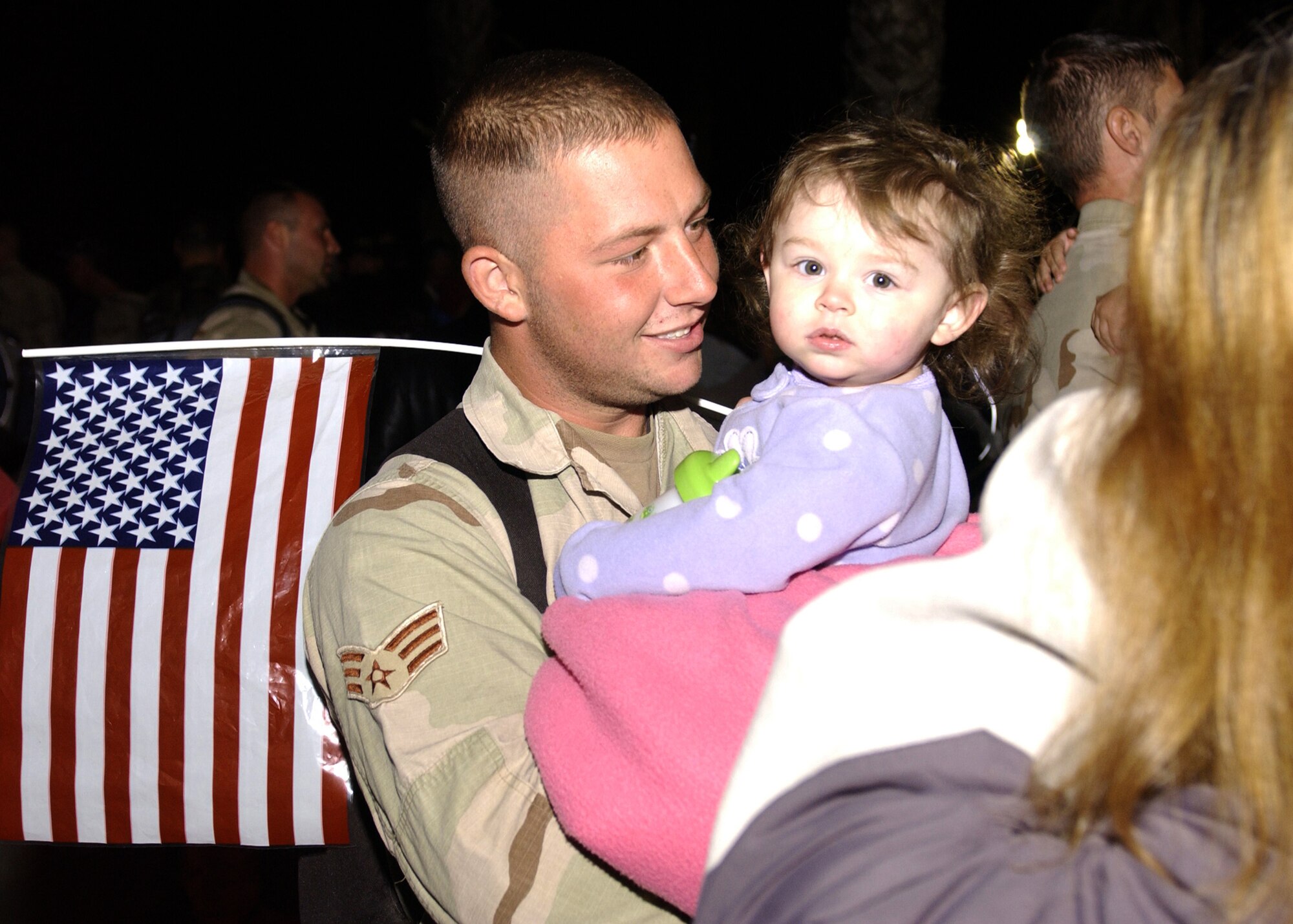 Senior Airman Ryan Phillips, 30th Civil Engineer Squadron,  reunites with his loved ones after landing on the Vandenberg flightline on December 7, 2006. Airman Phillips was one of 39 CE troops to return from deployment in support of the Global War on Terror. (U.S. Air Force photo by Airman 1st Class Christopher Hubenthal)                               