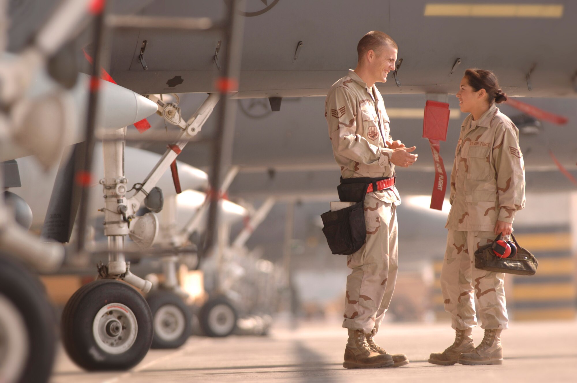 Staff Sergeants Chace and Maria Morris talk amid F-15E Strike Eagles Dec. 9 on the flightline at a forward-operating base in Southwest Asia. They have been married more than four years and are both deployed here supporting the war on terrorism. The two are 494th Expeditionary Aircraft Maintenance Squadron weapons loaders deployed from the 48th Aircraft Maintenance Squadron at Royal Air Force Lakenheath, United Kingdom. (U.S. Air Force photo/Master Sgt. Scott Wagers)