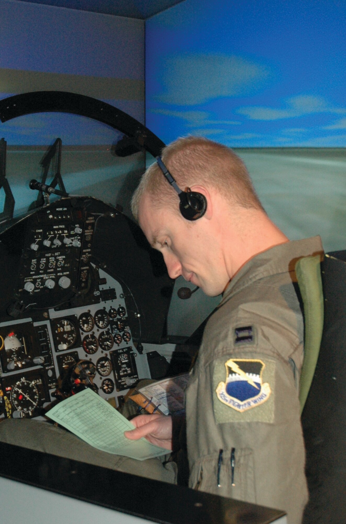 TYNDALL AIR FORCE BASE, Fla. --  Capt. Tim Bobinski, 2nd Fighter Squadron B-course student, performs a preflight checklist inside an F-15 Eagle simulator. (U.S. Air Force photo by Chrissy Cuttita)