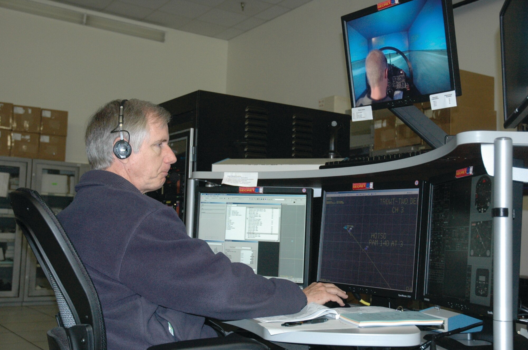 TYNDALL AIR FORCE BASE, Fla. --  Jim Miller, Lockheed Martin instructor pilot, runs through the pre-flight checklist with Capt. Tim Bobinski while he observes his actions in the F-15 simulator. Captain Bobinski is a 2nd Fighter Squadron B-course student. (U.S. Air Force photo by Chrissy Cuttita)
