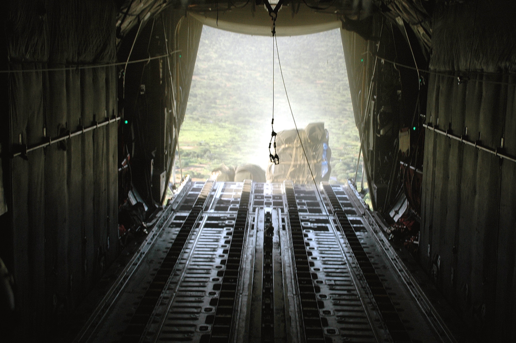 Supplies of tents, tarps and mosquito netting roll out the back of a C-130 Hercules during an air drop Dec. 9. The Air Force is dropping more than 240,000 pounds of supplies to flood refugees in eastern Kenya. After weeks of rain in Dadaab region in Kenya, camps housing about 160,000 Somali refugees who fled their country 14 years ago following an uprising were damaged and many crops were destoyed. The Combined Joint Task Force - Horn of Africa military officials monitoring the developments began Operation Unity Knight and sent an Air Force C-130 assigned to the 379th Air Expeditionary Wing based in Southwest Asia because the roads in the area were impassable. (U.S. Air Force photo/Tech. Sgt. Stephen Staedler)
